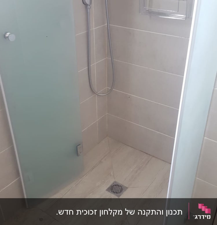 מקלחת עם ראש טוש, דלת זכוכית ומדף מתכת